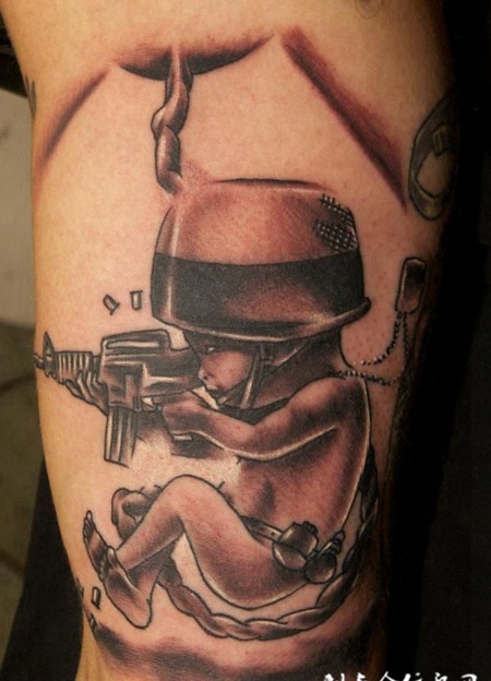 大臂上端着枪的小人纹身图案