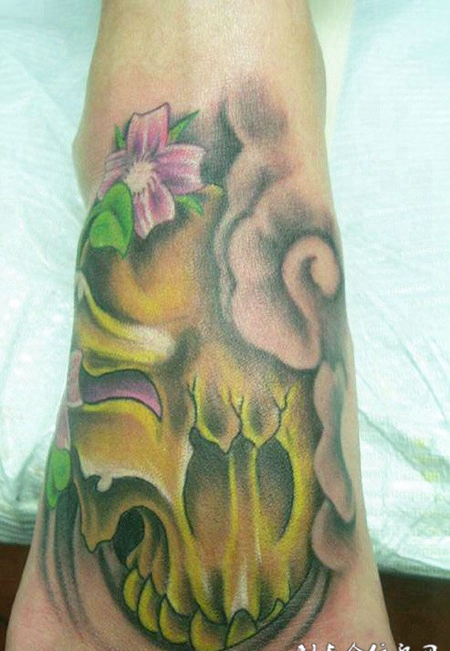 脚面上带着花朵的骷髅头纹身图案