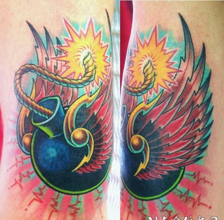 大臂上长翅膀的炸弹纹身图案