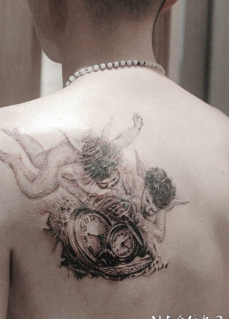 后背上抓着钟表的两只天使纹身图案