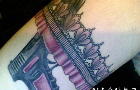 大臂上的蕾丝手枪纹身图案