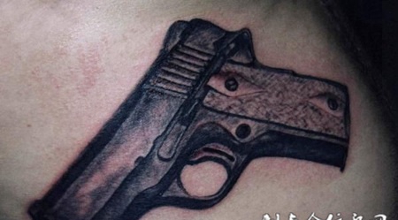 大臂上的手枪纹身图案