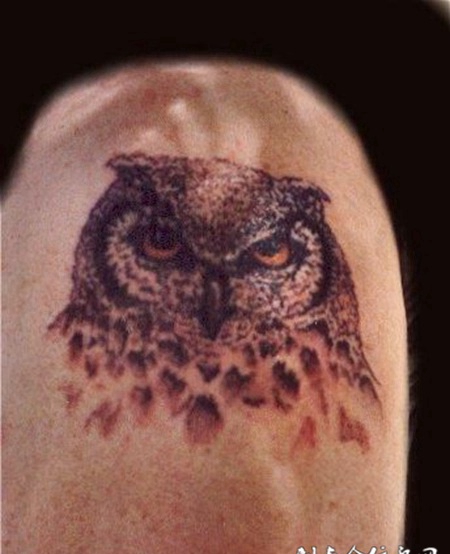 大臂上的猫头鹰头纹身图案