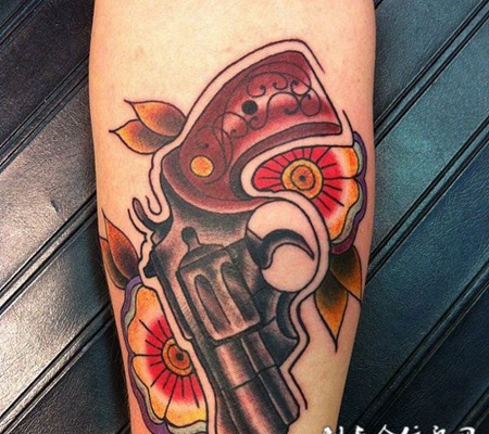 小臂上的花朵手枪纹身图案