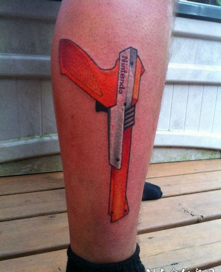 小腿上的红色手枪纹身图案