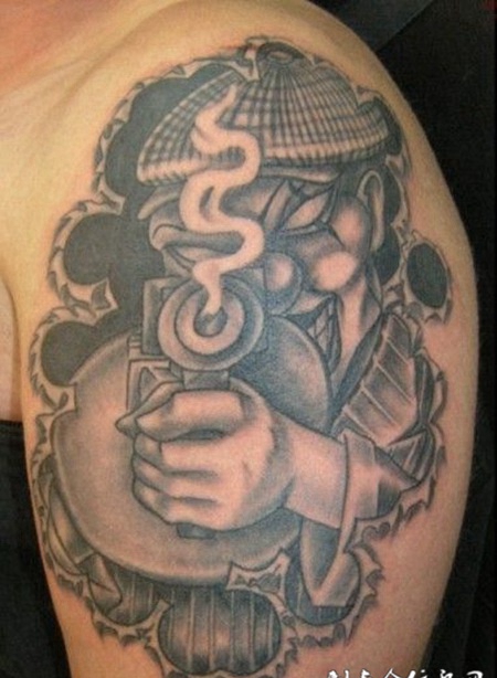 大臂上抱着火枪的小丑纹身图案