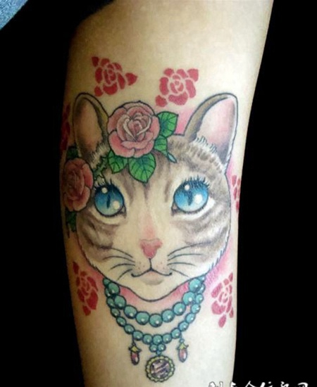 大臂上带着花的猫咪纹身图案