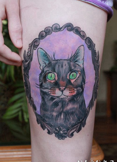 大腿上的绿眼猫咪纹身图案