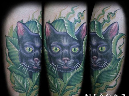 大臂上的树叶猫咪纹身图案