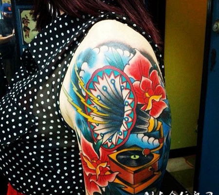 大臂上的音乐盒花朵纹身图案