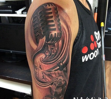 大臂上的麦克风墨水纹身图案