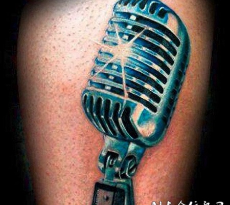 大臂上的金属麦克风纹身图案