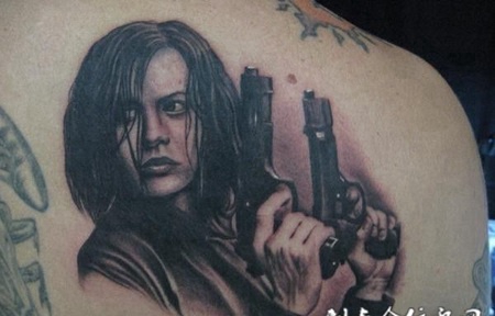 肩胛骨上拿着双枪的美女纹身图案