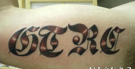 大臂上的花体字英文字母纹身图案