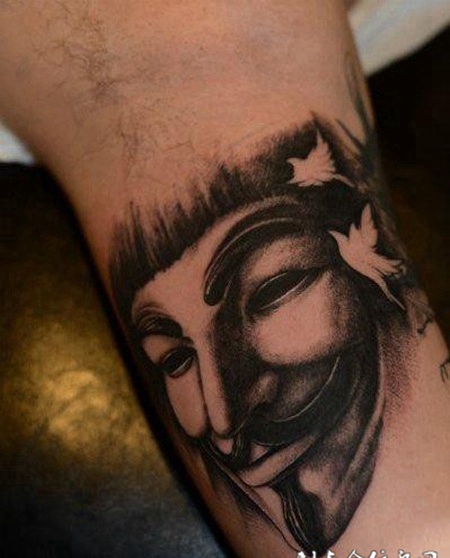大臂上的黑灰色V字仇杀队面具纹身图案