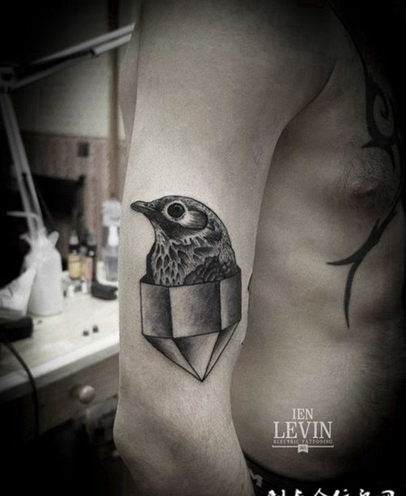 大臂上几何体中的小鸟纹身图案