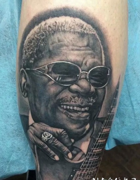 小腿上弹吉他的黑人纹身图案
