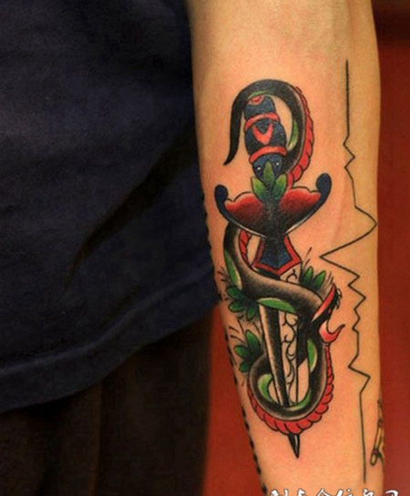 小臂上的蛇缠匕首的纹身图案