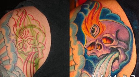 大臂上的遮盖骷髅头水花纹身图案