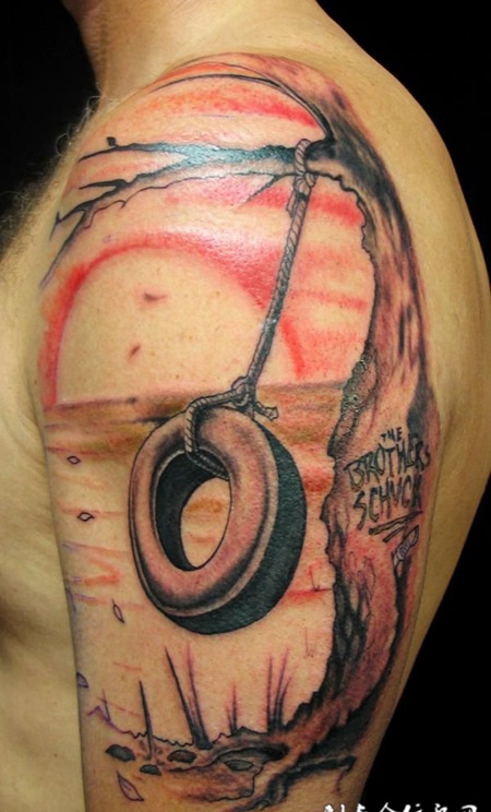 大臂上的枯树轮胎纹身图案