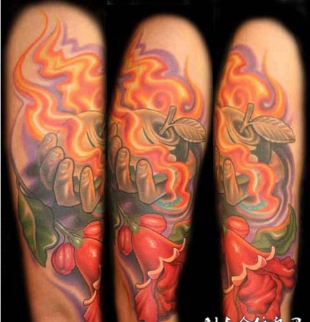 大臂上的托着苹果的手纹身图案