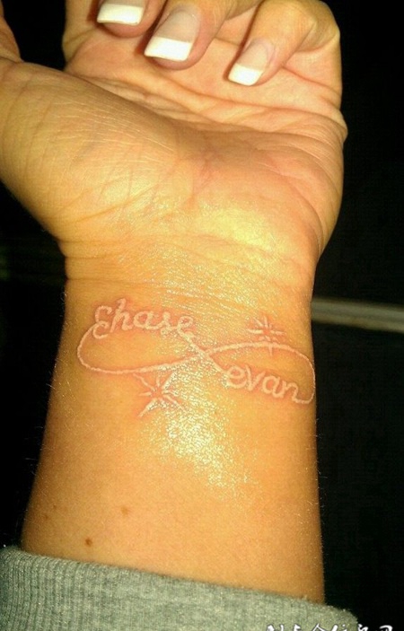 手腕处精致的英文图案鸽子血纹身