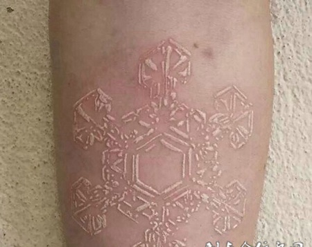 手臂上精美雪花图案鸽子血纹身作品