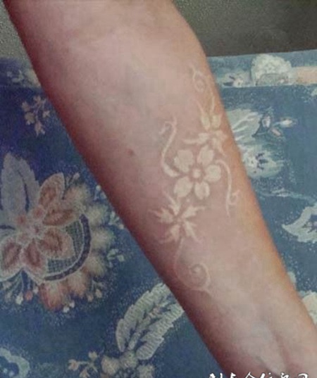 手臂上简单精致的鸽子血梅花纹身