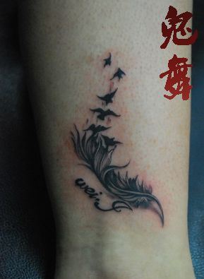 腿部时尚的羽毛小鸟纹身图案