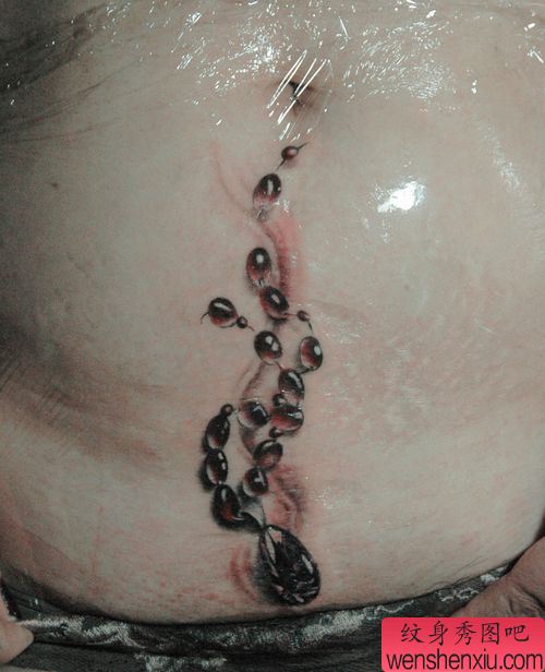 女孩子腹部一幅钻石吊链纹身图案