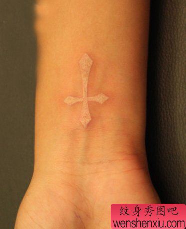 女生手腕处一幅白色图腾十字架纹身图案