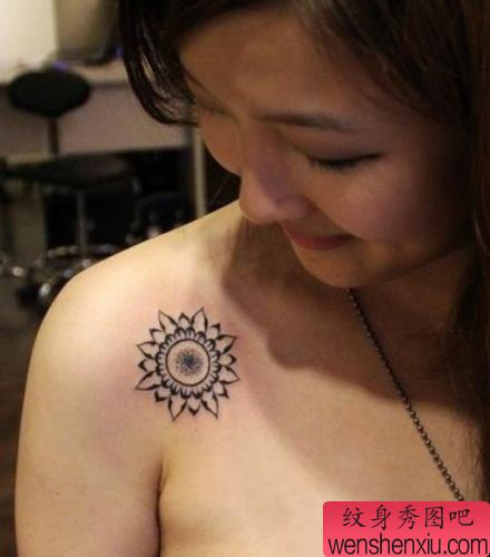 女生肩膀处精美的图腾太阳纹身图案