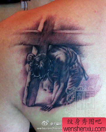 男性肩背一幅黑灰耶稣纹身图案