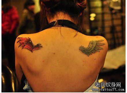 女孩子肩背时尚的一半天使一般恶魔的翅膀纹身图案