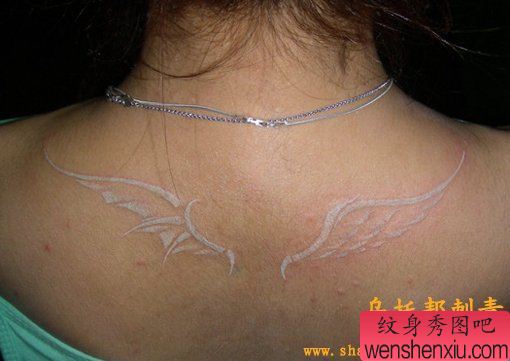 女人肩部一幅白色翅膀纹身图案