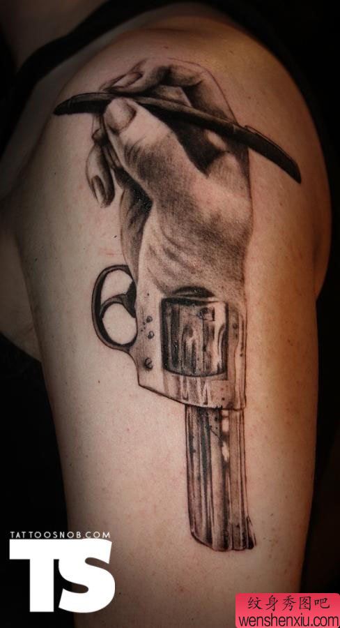 胳膊一幅创意手和枪文身作品