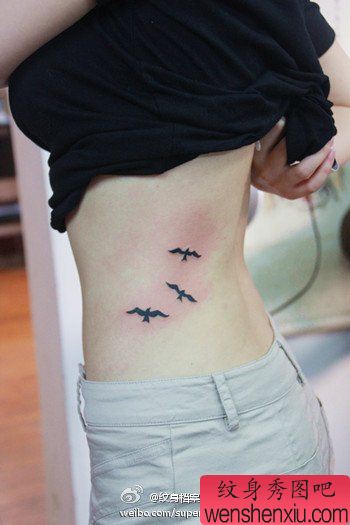 女生腰部流行小巧的图腾小鸟纹身图案