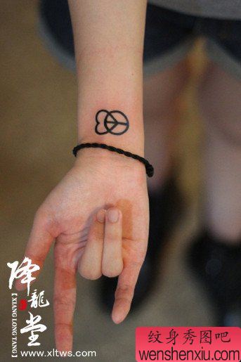 女生手腕小巧的爱心与反战符号纹身图案