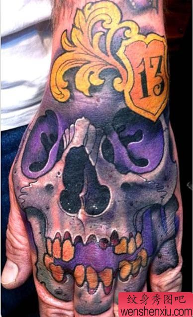 手背上一幅紫色骷髅纹身图案