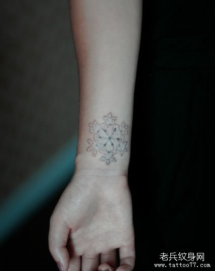 女孩子手腕处一款白色雪花纹身图案