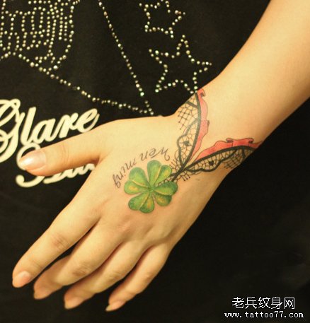 女生手腕处蕾丝四叶草手链纹身图案