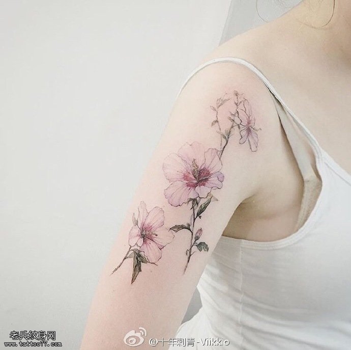 大臂上清新的花卉纹身图案
