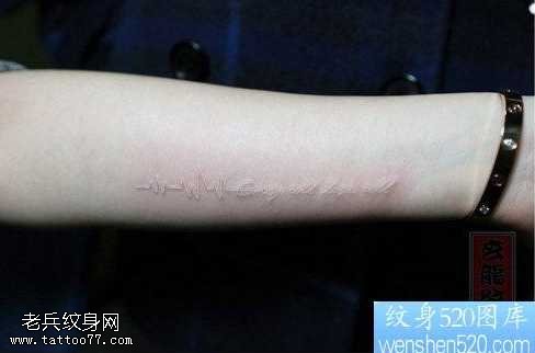 手臂白色心电图与字母纹身图案