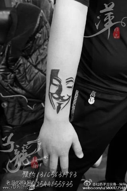 手臂上简单大气的人头像纹身迤