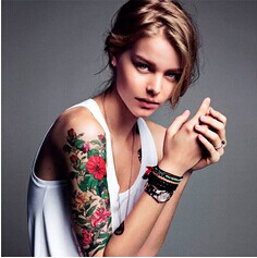 美女手臂红花与绿叶纹身图片