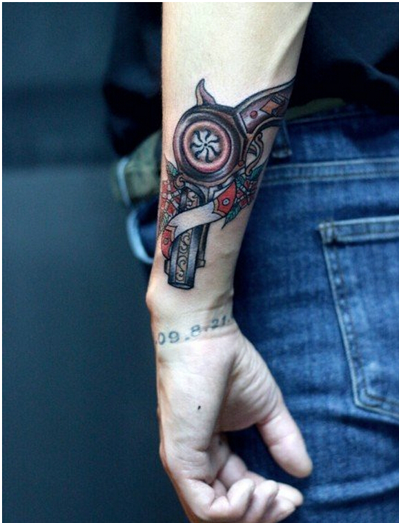 手臂上时尚好看的彩色手枪纹身图案图片