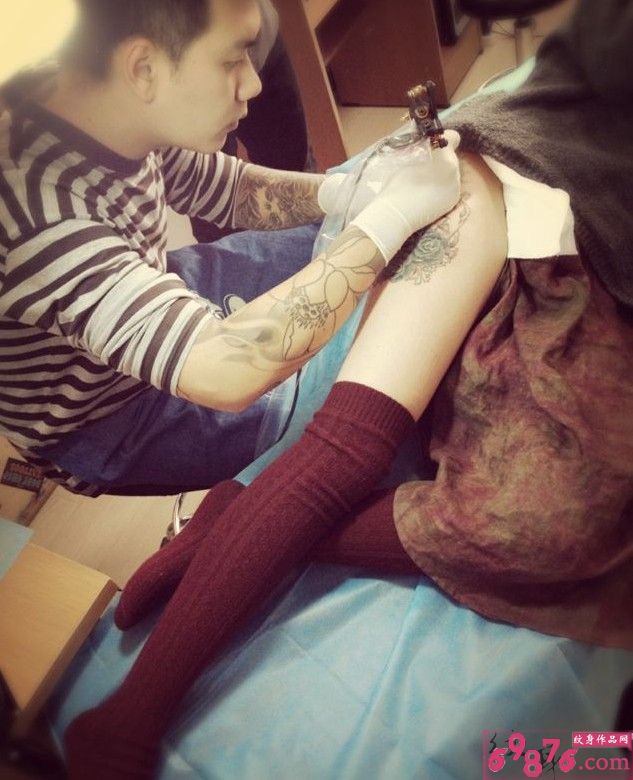 帅哥纹身师大腿花纹身现场图片
