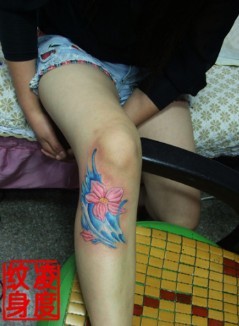 腿部膝盖上的蓝底红花图案纹身图片