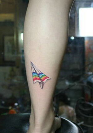 腿部一枚时尚好看的七彩纸飞机纹身图图片