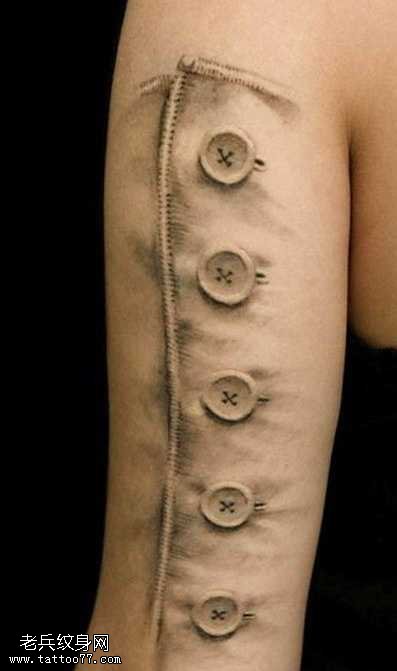 大臂逼真的纽扣纹身图案